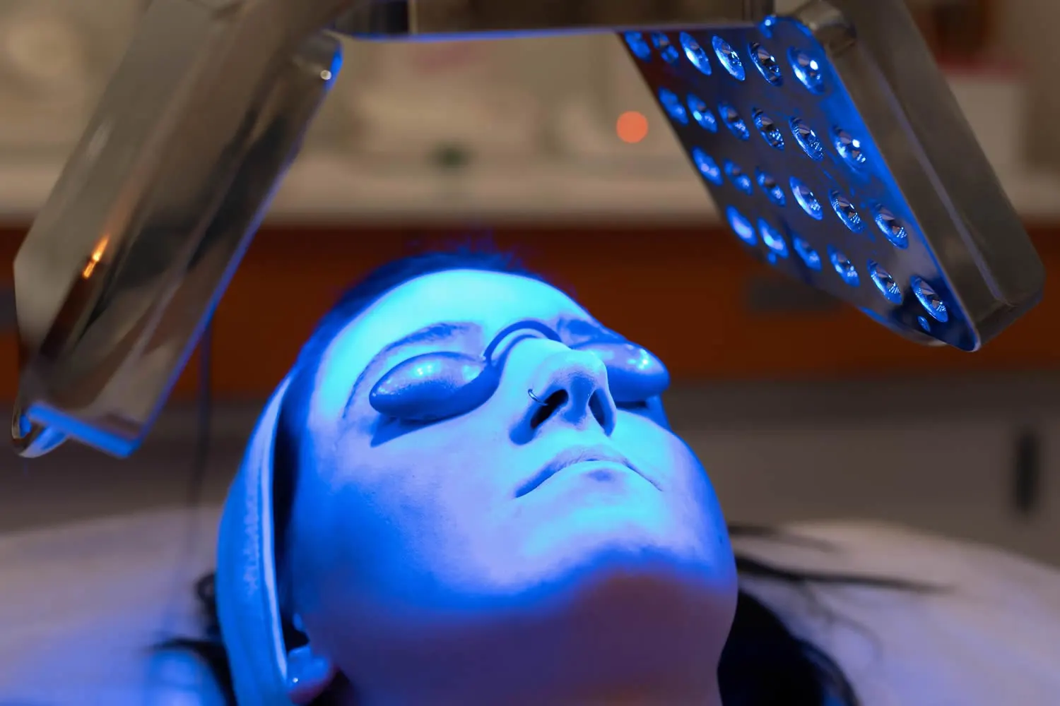 woman-having-blue-led-light-facial-therapy-at-dermatology-office